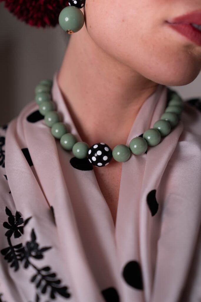 cuello con mantoncillo rosa bebe de lunares y colgante corto de bolas verde agua con una bola en medio mas grande negra con lunares blancos